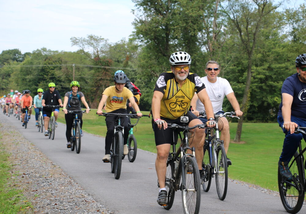Cyclists travel along a gravel path.