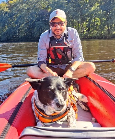 wes bernstein and dog peanut on a boat in the river